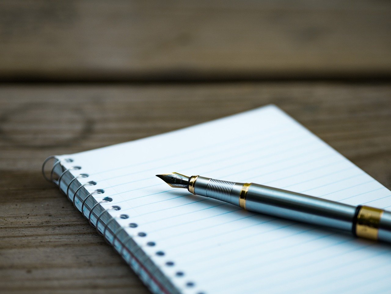 carnet à spirale, stylo plume ouvert sur un bureau en bois